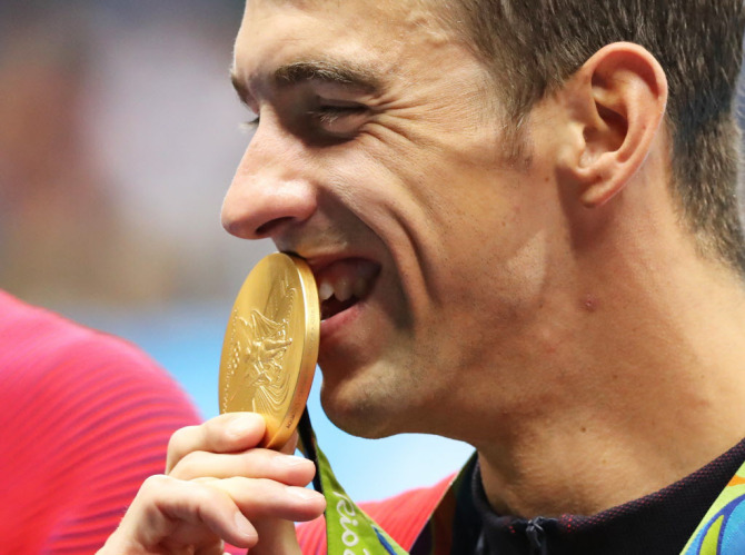 Michael Phelps kisses his gold medal after the men's 4 x 100-meter medley relay final on Sunday. (AP Photo/Lee Jin-man)
