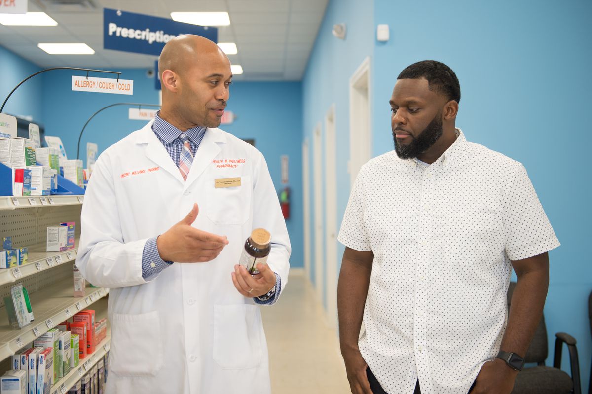 Vincent Williams and Bernard Macon discuss medication at LV Health and Wellness Pharmacy in Shiloh, Ill., on June 6, 2019. (Michael B. Thomas for Kaiser Health News)