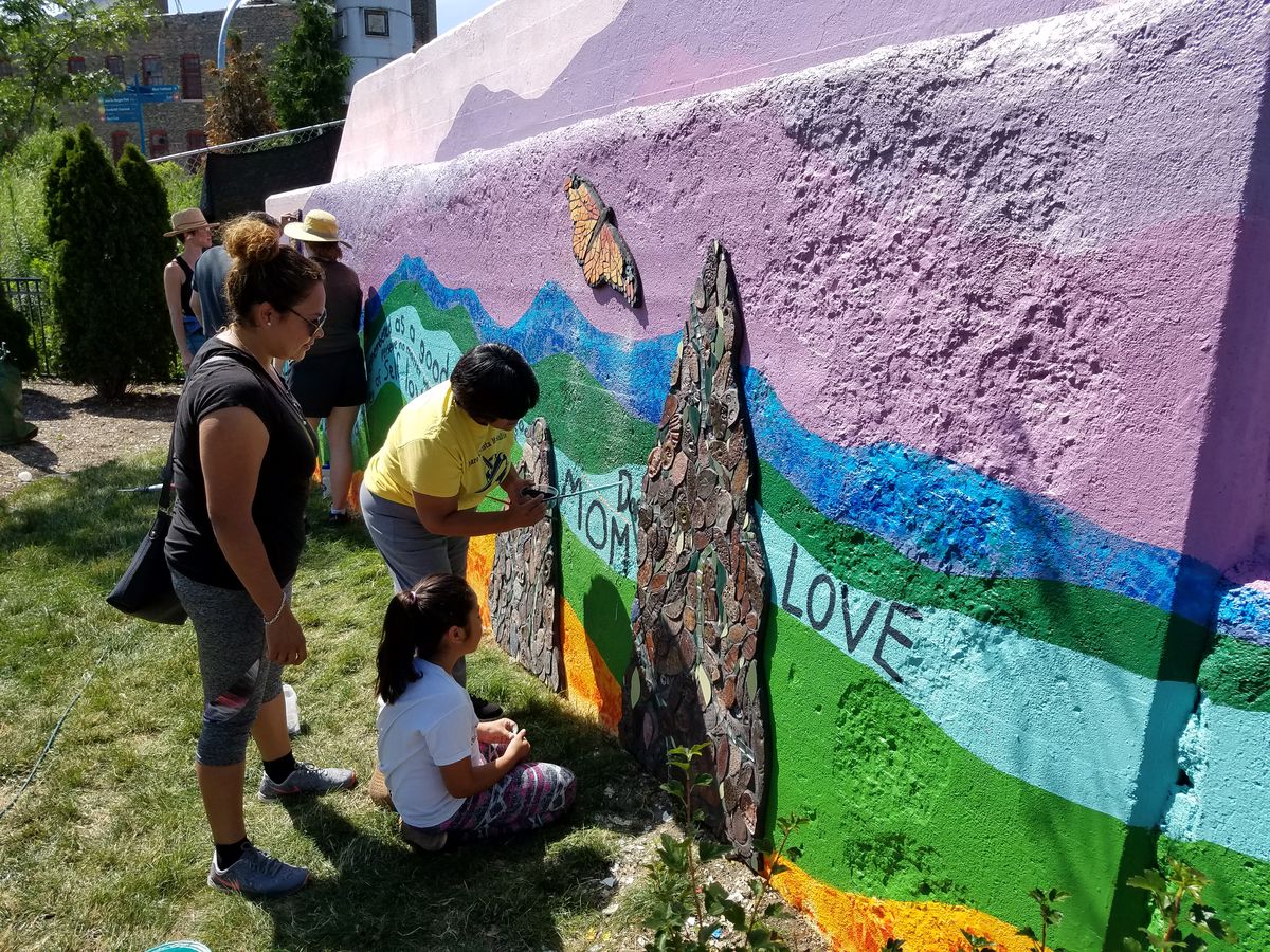 Students and parents work on a mural and mosaic project in 2017 near McAuliffe Elementary School in Logan Square that the school’s students created.