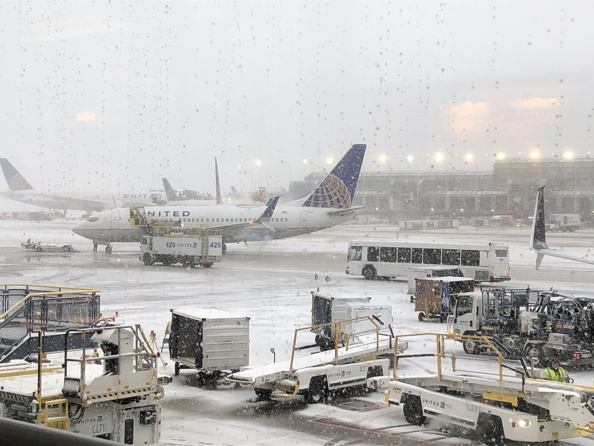 Snow falling on the United Airlines terminal at O’Hare International Airport Monday.