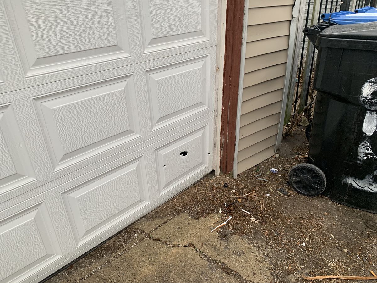 Several bullet holes could be seen in a garage door near the scene of a deadly shooting Monday in the 6200 block of South Mozart that left two men dead.