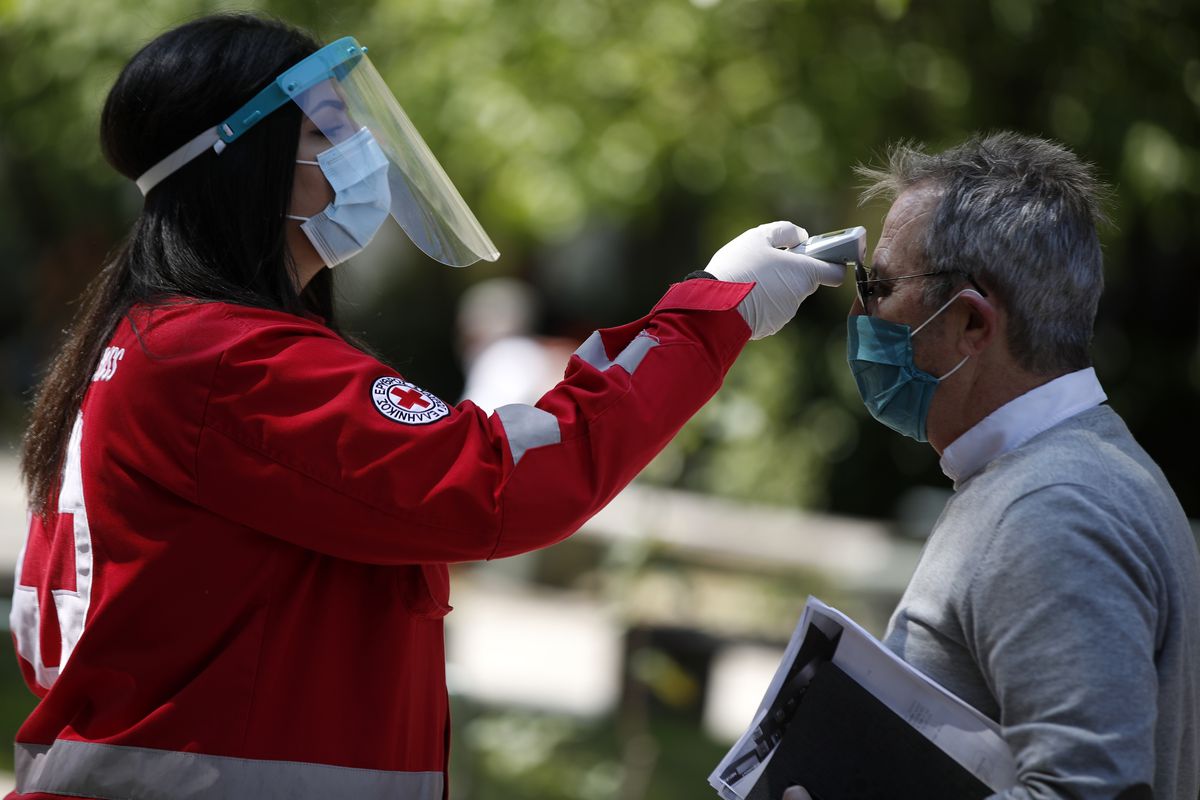 Temperature checks, like this one being conducted outside a courts complex in Greece this week, could be required to enter City Hall and other buildings once shelter-in-place orders are lifted, Chicago Mayor Lori Lightfoot said Tuesday.