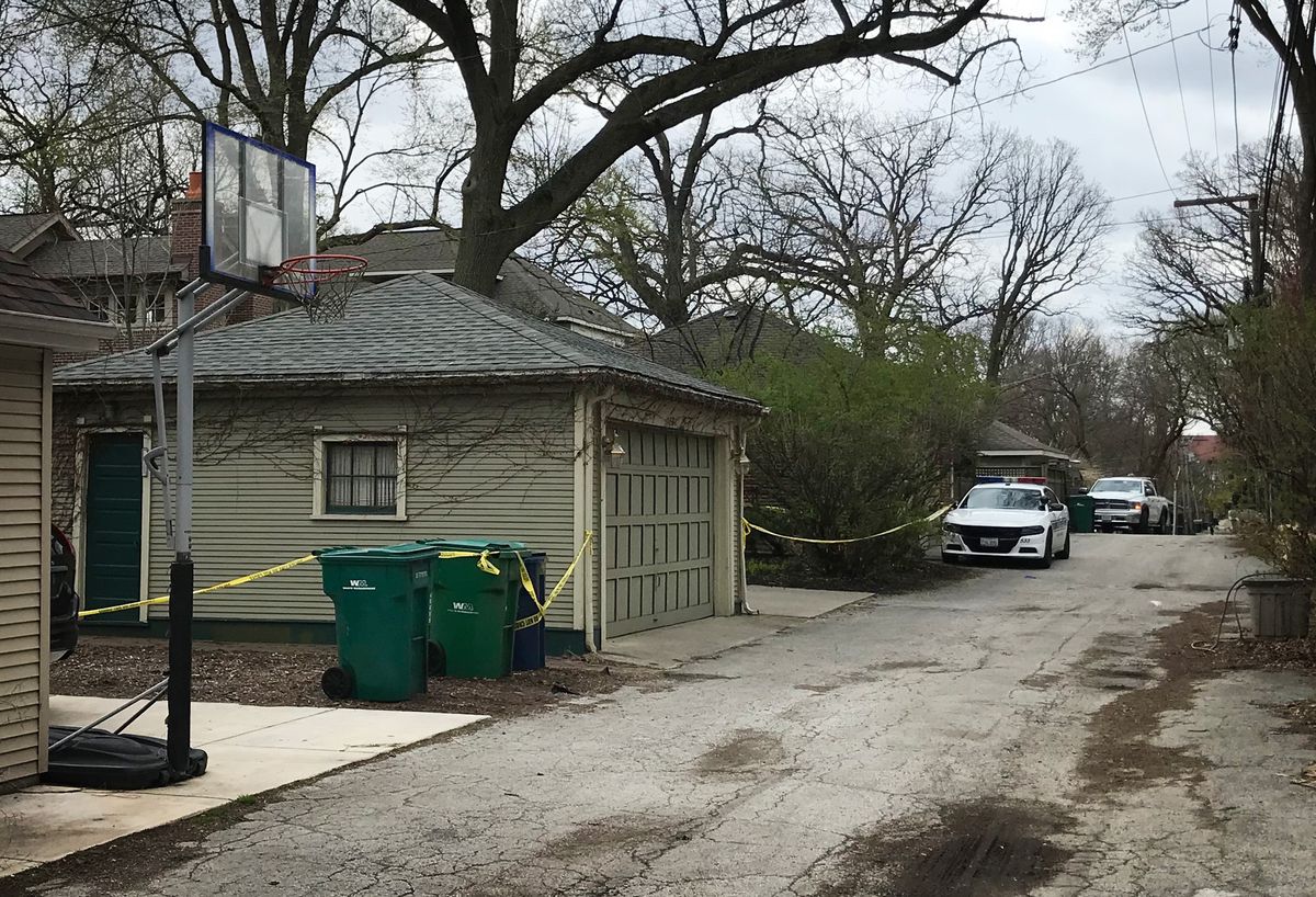 A police vehicle guards the alley of a home in the 500 block of Fair Oaks Avenue in Oak Park, where police found two dead bodies the previous night, April 13, 2020.