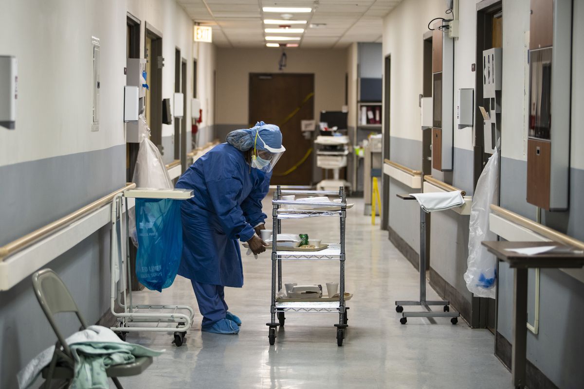 Nurse Jeanette Averett delivers dinner trays in the COVID-19 unit at Roseland Community Hospital on the Far South Side, Tuesday afternoon, April 28, 2020. During a standard 12-hour day shift Tuesday, nurses responded to five code blues and three patients died of the coronavirus.