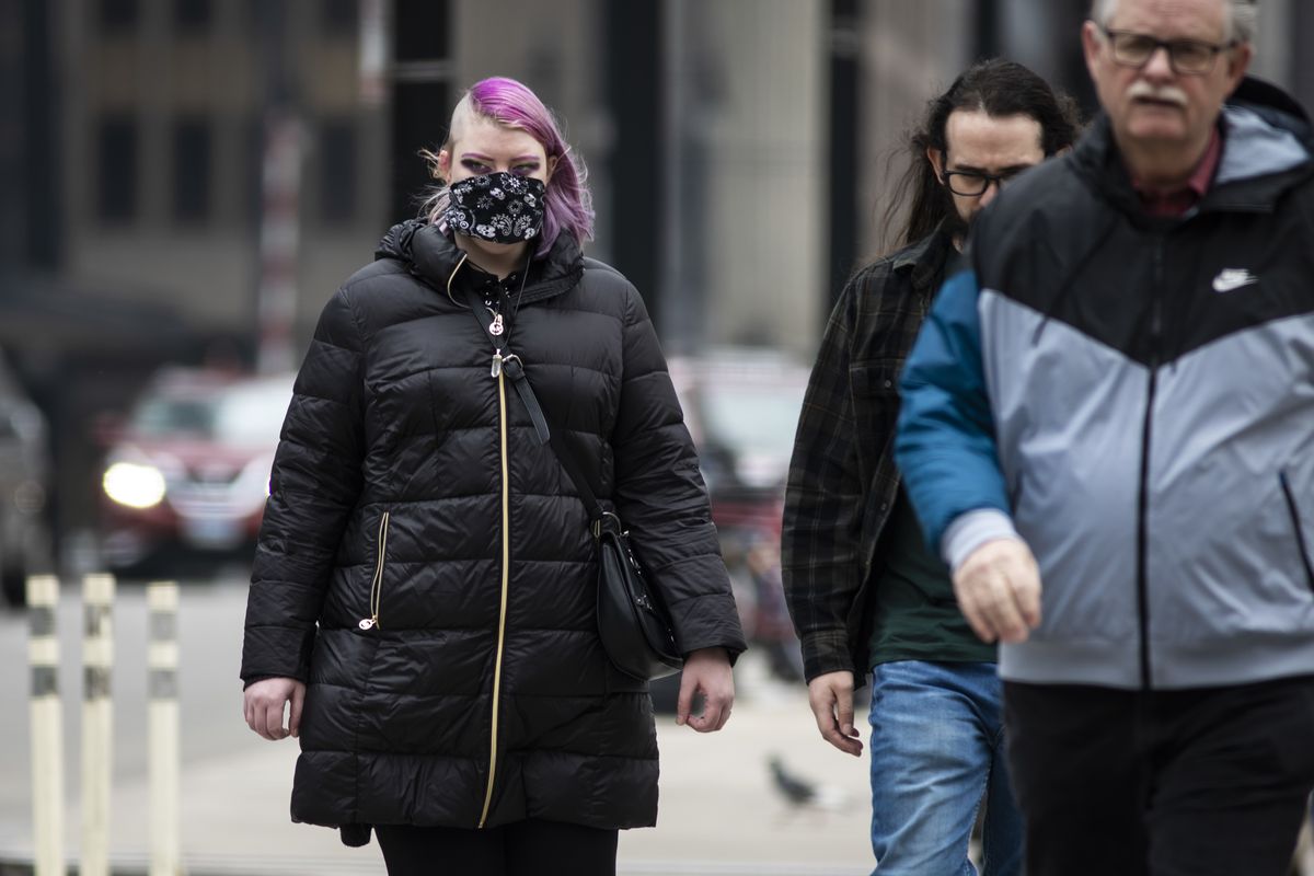 A woman in the Loop wears a face mask Thursday amid growing fear about the coronavirus.