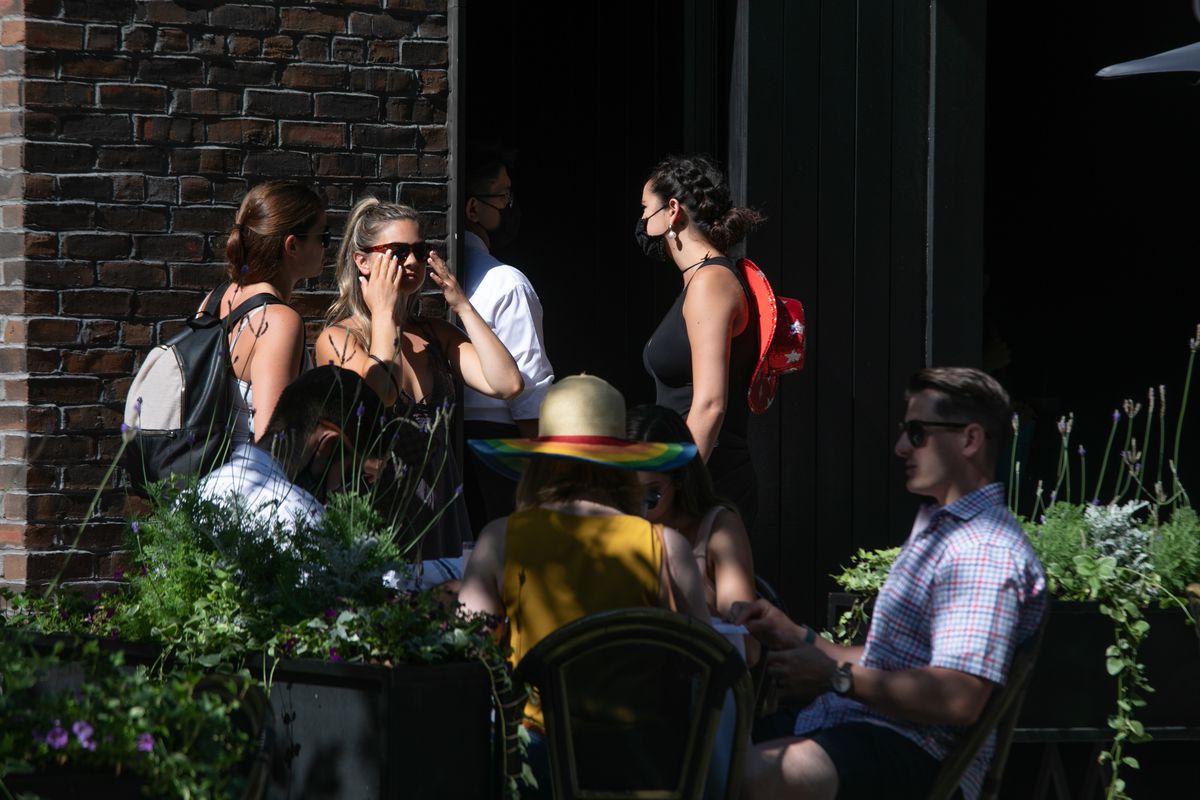 Nine Millennials are seen enjoying a day out at a venue on Chicago’s Gold Coast Saturday — only two are wearing masks.