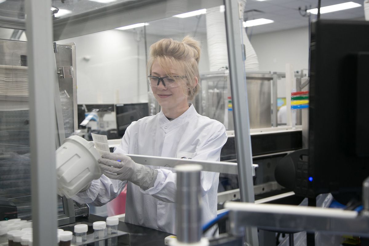 A specimen processing associate adds an identifying label to a sample jar at Exact Sciences Laboratories in Madison. Keeping track of patient information is key to the process.