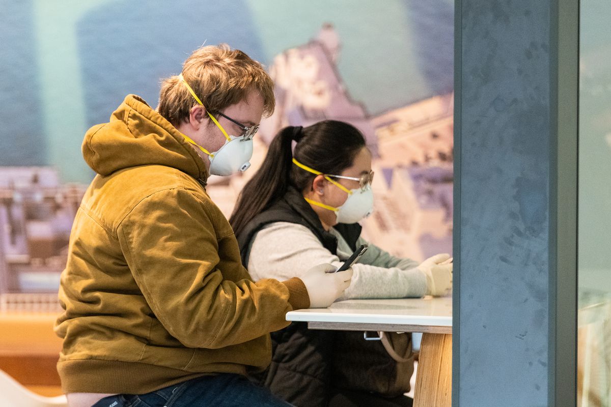 A couple wears face masks and latex gloves Friday in the international terminal at O’Hare Airport.