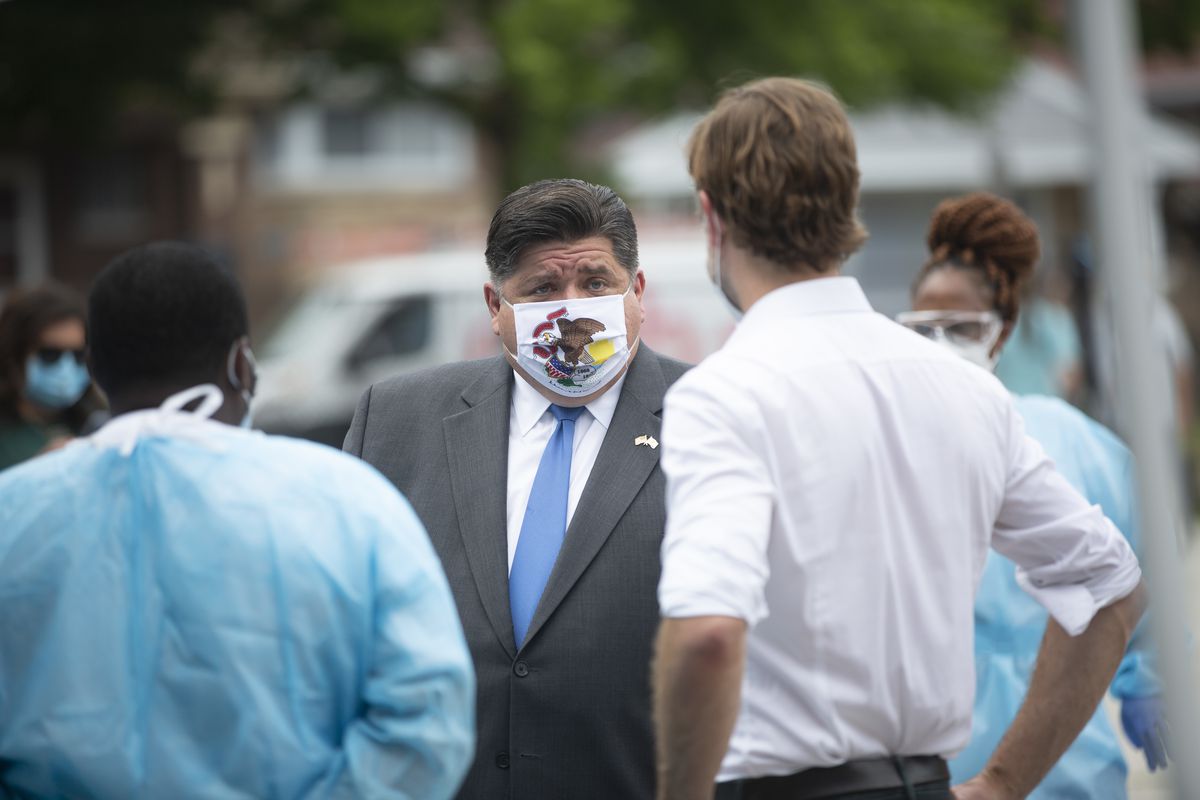 Gov. J.B. Pritzker speaks to medical personnel during a visit to a mobile COVID-19 testing station at Edward Coles School in the South Chicago neighborhood July 8.