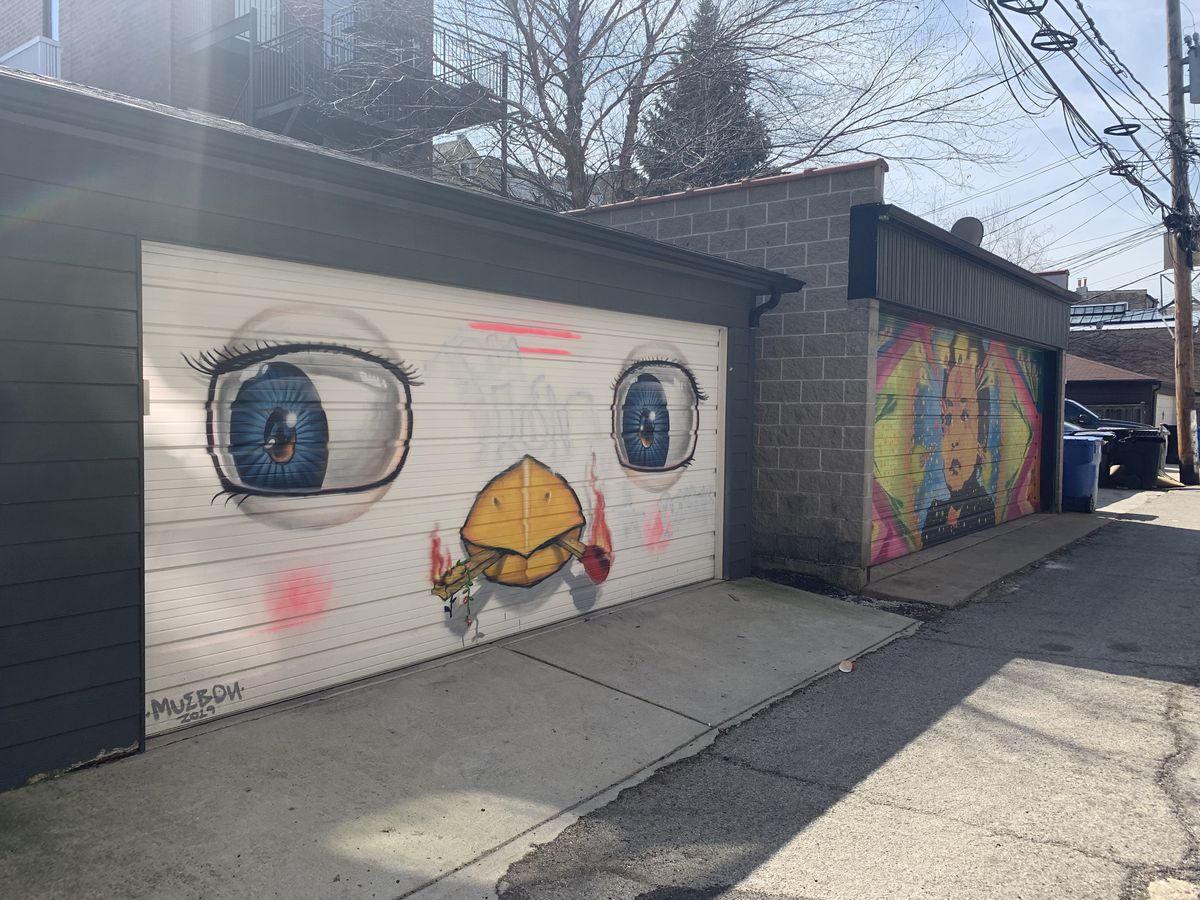 What started as a single mural on a garage door blossomed into more than a dozen large-scale paintings by artists from around the world in an alley between Noble and Bishop streets in West Town. The mural at left is by Thai artist Mue Bon. The other is by the Colombian artist known as Stinkfish.