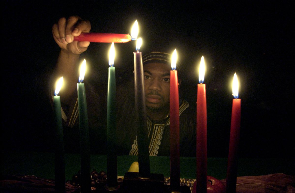 Ricky Rodgers lights a kinara at a Kwanzaa event in Aurora in 2004. Each flame represents one of seven principles of Kwanzaa.