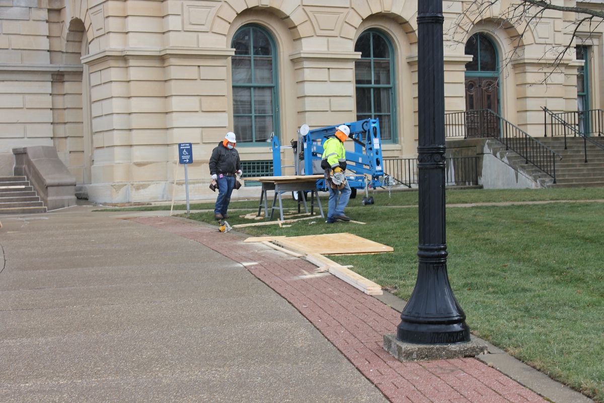 Crews prepare to cover windows at the Illinois State Capitol with plywood on Friday to protect against possible demonstrations.